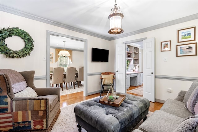 living room with an inviting chandelier, crown molding, and light wood-style flooring