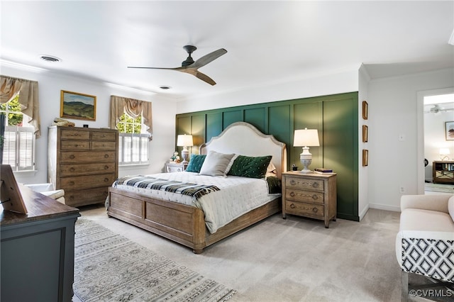 bedroom featuring visible vents, ornamental molding, a ceiling fan, and light carpet