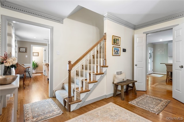 stairs featuring baseboards, ornamental molding, recessed lighting, and wood finished floors