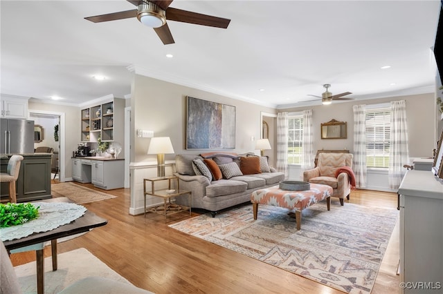 living area with ornamental molding, light wood-type flooring, a ceiling fan, and recessed lighting