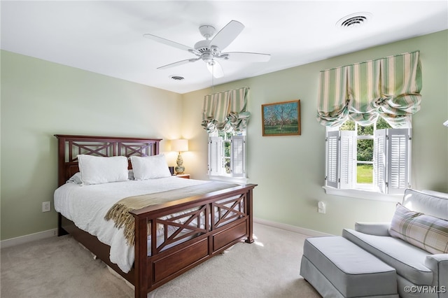 bedroom featuring light colored carpet, baseboards, ceiling fan, and visible vents