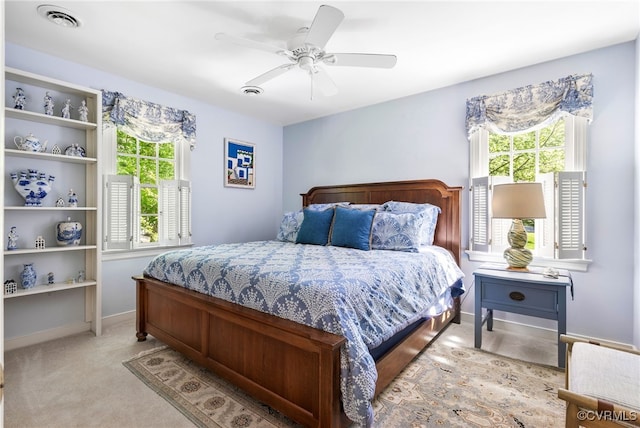 bedroom featuring visible vents, a ceiling fan, baseboards, and multiple windows