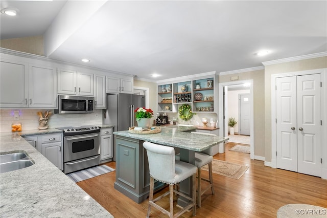 kitchen with a center island, tasteful backsplash, open shelves, light wood-type flooring, and stainless steel appliances