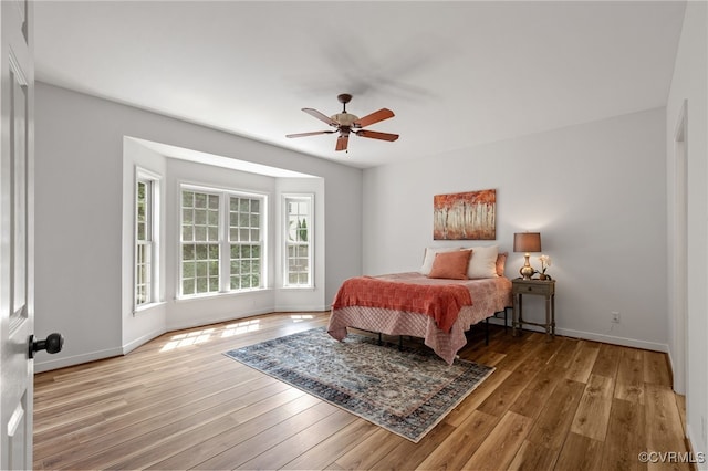 bedroom with wood-type flooring, baseboards, and ceiling fan