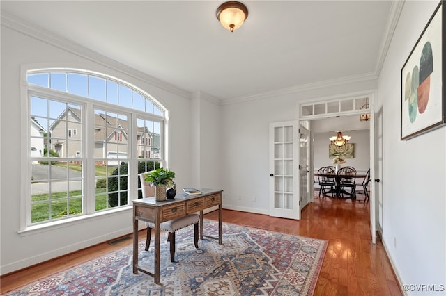 office space featuring crown molding, baseboards, wood finished floors, and a healthy amount of sunlight