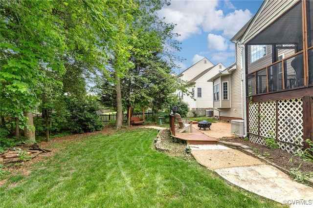 view of yard featuring fence, cooling unit, and a fire pit