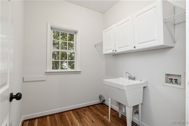 laundry area with cabinet space, a sink, hookup for a washing machine, baseboards, and dark wood-style floors