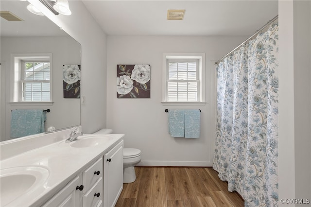 bathroom with visible vents, a sink, wood finished floors, and toilet