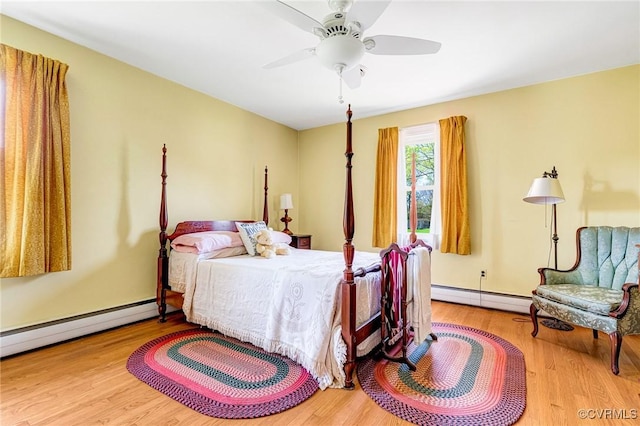 bedroom with wood finished floors, a ceiling fan, a baseboard heating unit, and baseboard heating