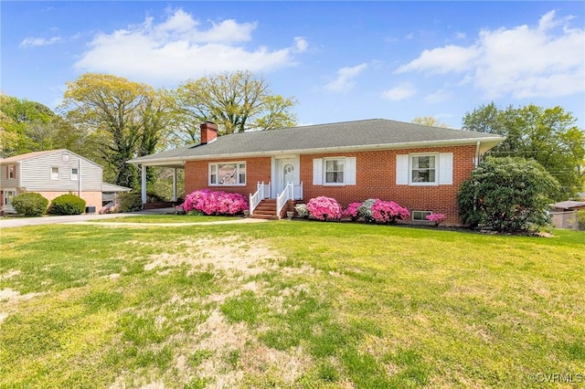 ranch-style home with brick siding, a front lawn, an attached carport, and a chimney