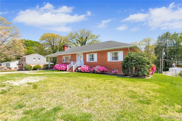 single story home featuring brick siding, a front lawn, and a chimney