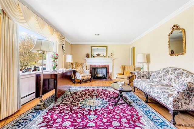 living room with ornamental molding, a baseboard heating unit, a brick fireplace, and wood finished floors