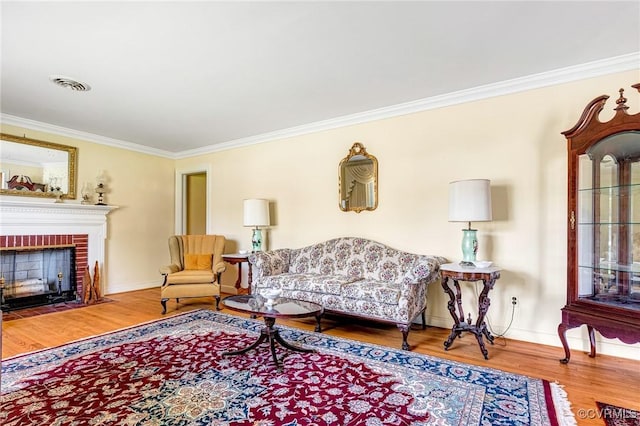 living area with crown molding, baseboards, visible vents, and wood finished floors