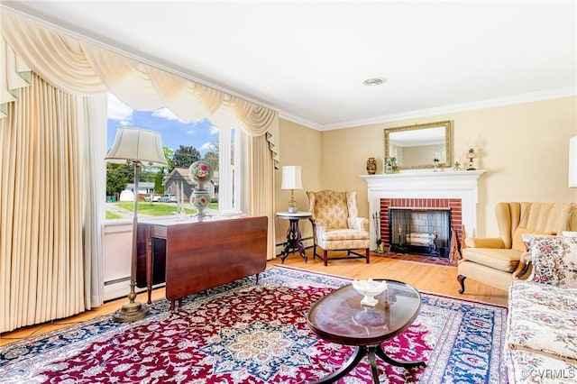 living area with ornamental molding, wood finished floors, baseboard heating, and a fireplace