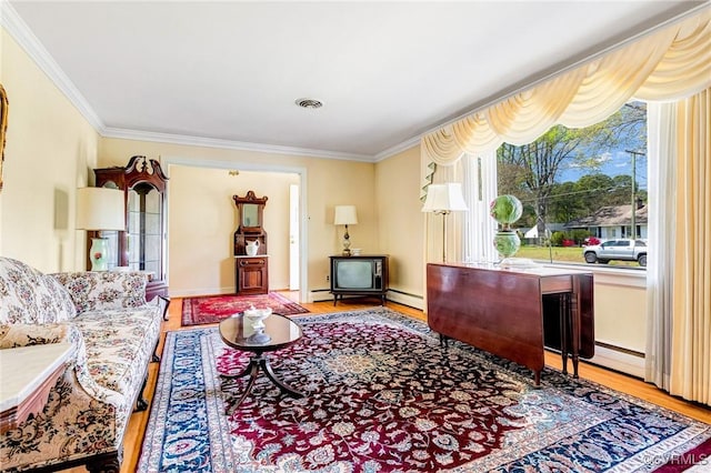 interior space featuring visible vents, ornamental molding, a baseboard radiator, and wood finished floors
