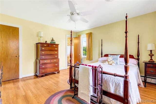 bedroom with light wood-style floors, baseboards, a ceiling fan, and a baseboard heating unit