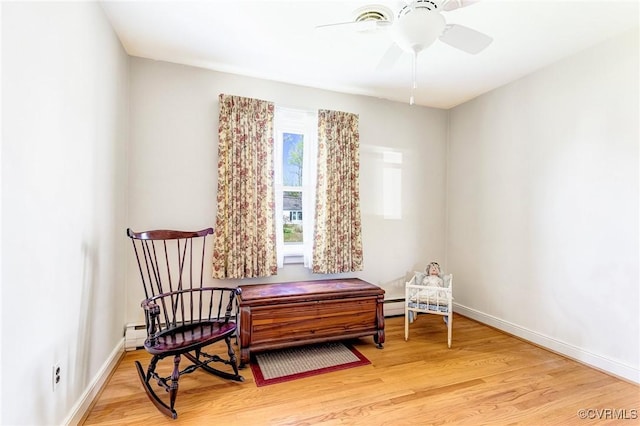 living area featuring baseboards, ceiling fan, and light wood-type flooring