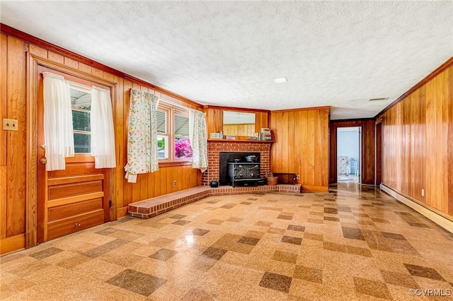 unfurnished living room with a textured ceiling, visible vents, baseboards, wooden walls, and light floors