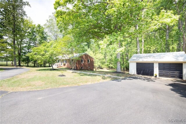 view of front of house with an outbuilding, a front lawn, and a garage
