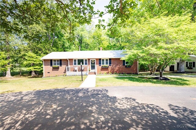 ranch-style home with a front yard, aphalt driveway, and brick siding