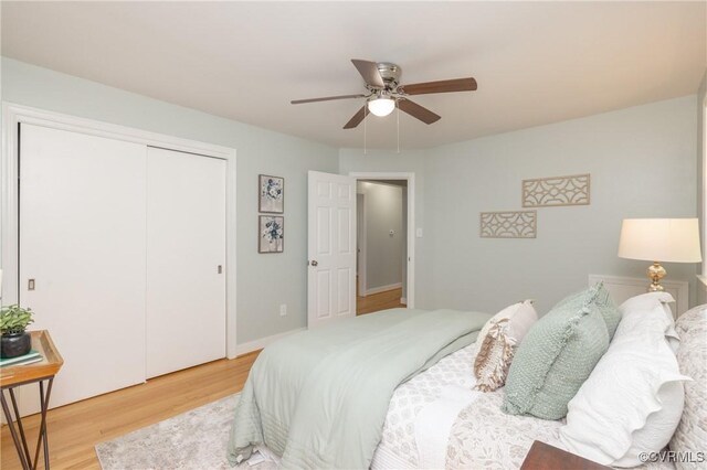 bedroom with a closet, a ceiling fan, and light wood finished floors
