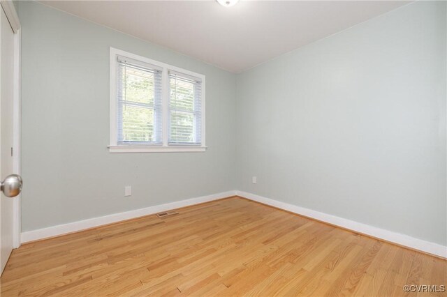 unfurnished room featuring baseboards, visible vents, and light wood-type flooring