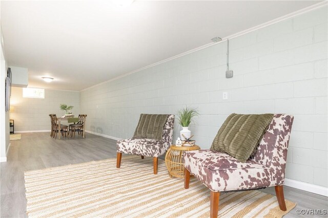 living area with crown molding, baseboards, and wood finished floors