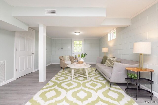 living room featuring visible vents, baseboards, and wood finished floors