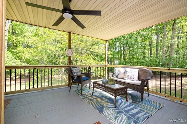 wooden terrace with ceiling fan and an outdoor living space