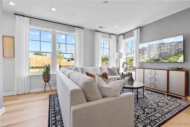 living area with recessed lighting, baseboards, visible vents, and wood finished floors
