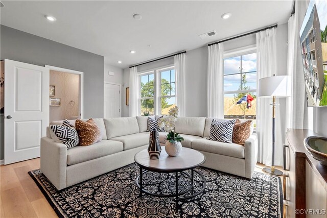 living area featuring recessed lighting, light wood-style flooring, and visible vents