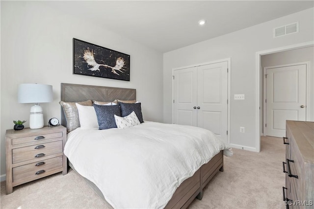 bedroom featuring light colored carpet, baseboards, visible vents, and a closet