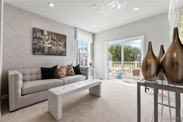 carpeted living area with recessed lighting, baseboards, and an accent wall