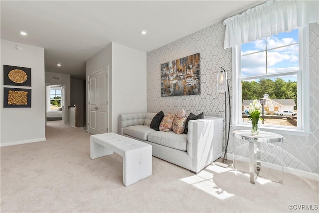 carpeted living room with baseboards, recessed lighting, an accent wall, and visible vents
