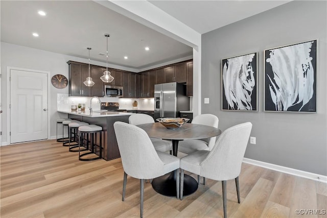 dining area featuring recessed lighting, baseboards, and light wood-type flooring