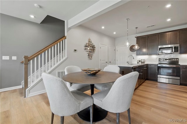 dining space with stairs, recessed lighting, visible vents, and light wood finished floors