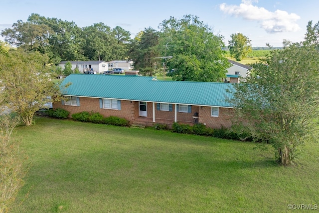 ranch-style house with brick siding, a front yard, and metal roof