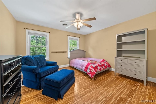 bedroom with a ceiling fan, baseboards, visible vents, and light wood-style floors
