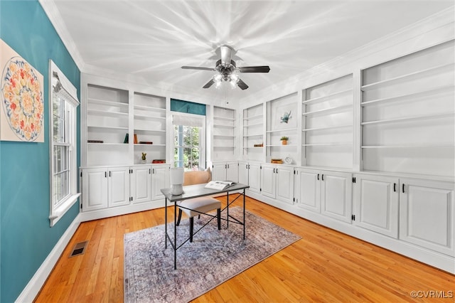 office area with a ceiling fan, visible vents, built in features, ornamental molding, and light wood-style flooring