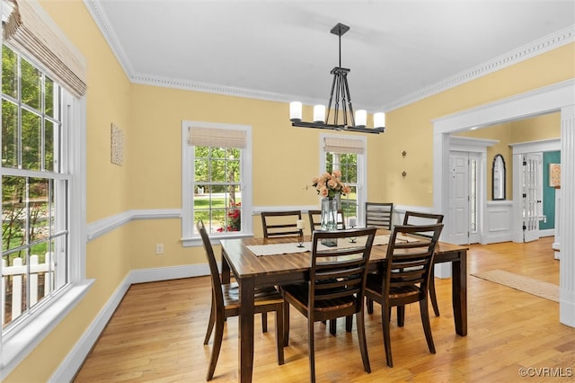 dining room with baseboards, a chandelier, ornamental molding, and light wood-type flooring