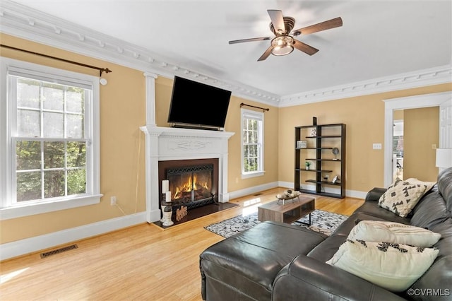 living room featuring visible vents, baseboards, ceiling fan, and wood finished floors