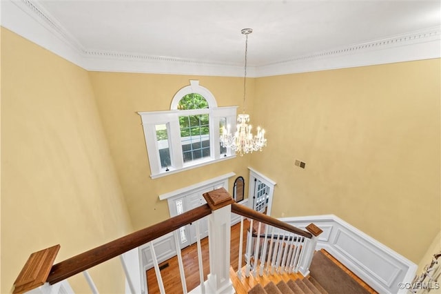 stairs featuring crown molding, wood finished floors, a chandelier, and visible vents