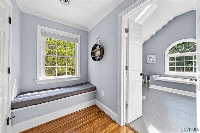 corridor featuring crown molding, baseboards, vaulted ceiling, and visible vents