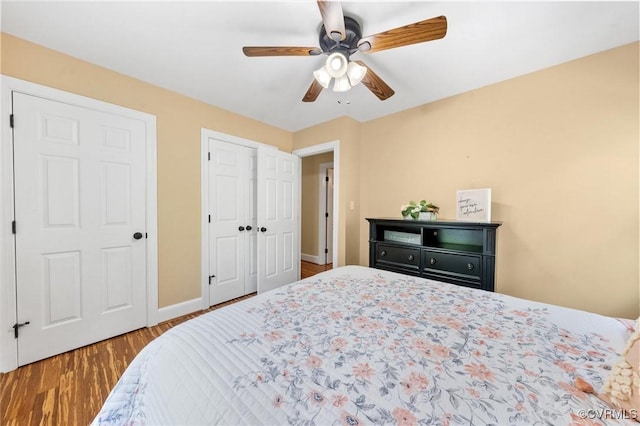 bedroom featuring a ceiling fan, baseboards, and wood finished floors
