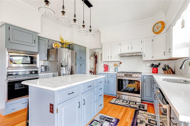 kitchen featuring a sink, appliances with stainless steel finishes, gray cabinets, and ornamental molding