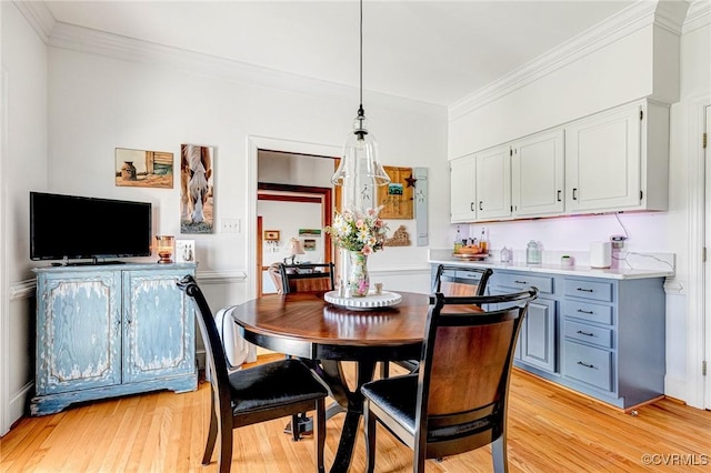 dining room featuring ornamental molding and light wood finished floors