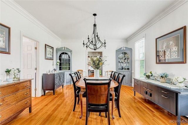 dining space featuring crown molding, a notable chandelier, and light wood-type flooring