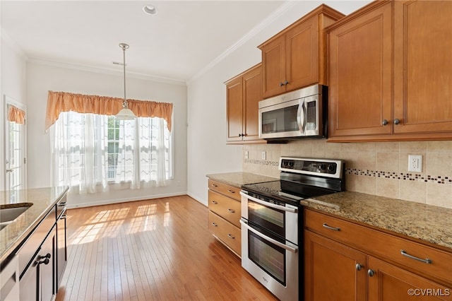 9533 Ashleyville Turn, Midlothian, VA 23112 - kitchen featuring appliances with stainless steel finishes, light wood-type flooring, light stone countertops, brown cabinets, and ornamental molding