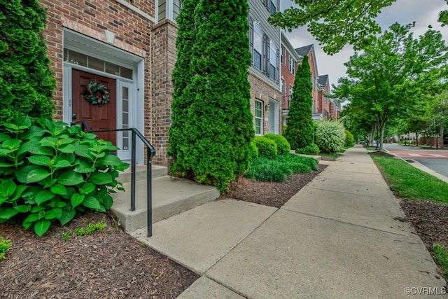 view of exterior entry with brick siding