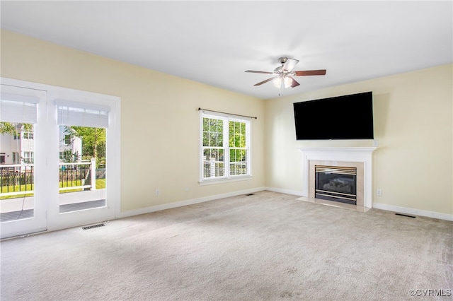 unfurnished living room featuring visible vents, a fireplace with flush hearth, carpet floors, and ceiling fan